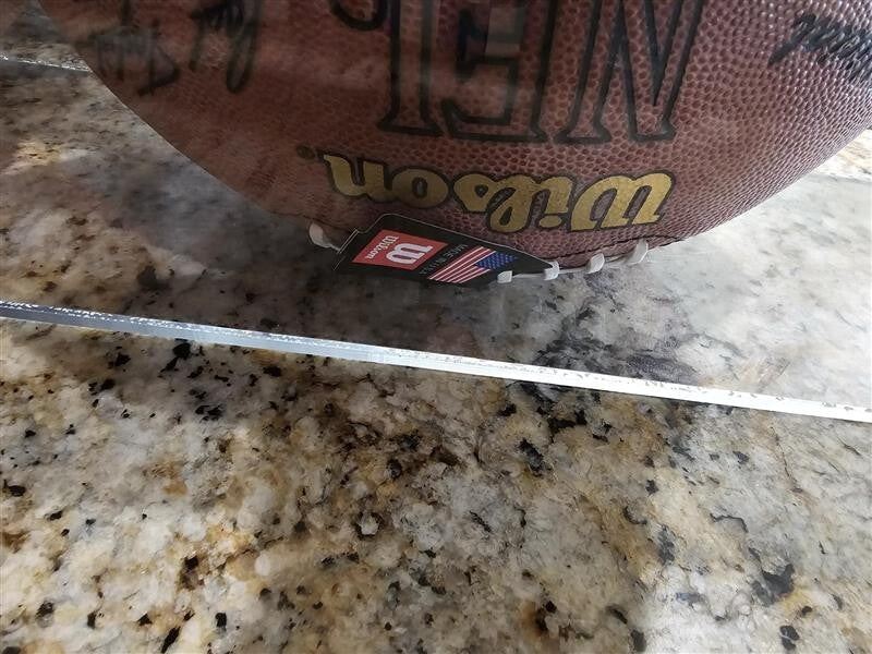 Bart Starr, Joe Perry, and Roger Staubach signed footballs in Display case