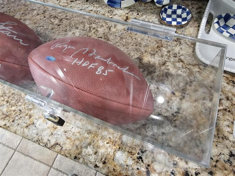 Bart Starr, Joe Perry, and Roger Staubach signed footballs in Display case