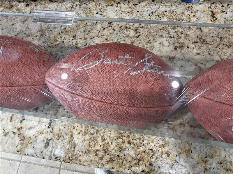 Bart Starr, Joe Perry, and Roger Staubach signed footballs in Display case
